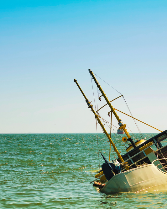 Sinking boat in the middle of the ocean.